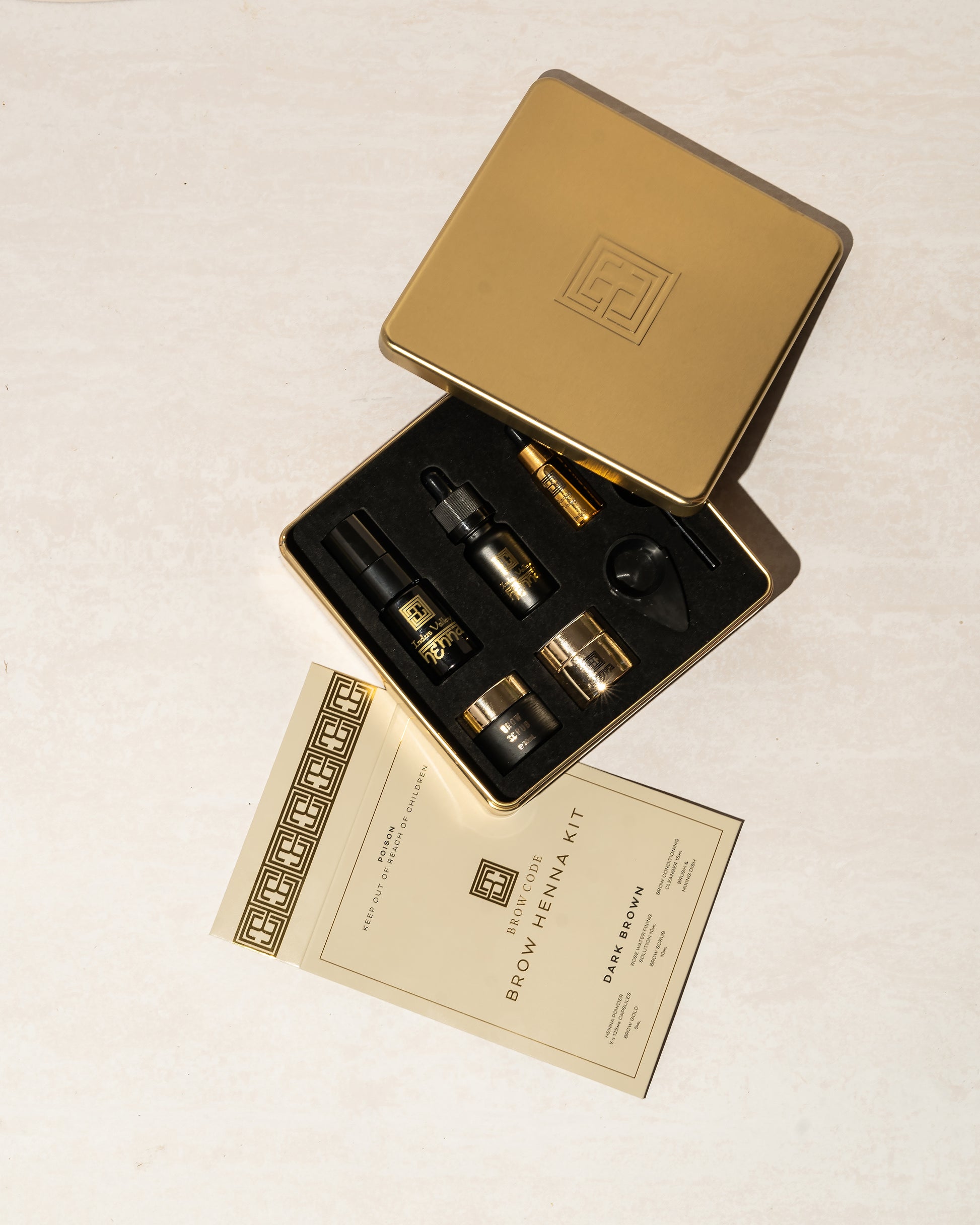 Brow Code AT HOME KIT Brow Henna in 4 Farben mit Fläschchen, Pinsel und Anleitung auf einer hellen Unterlage. Blashy Shop