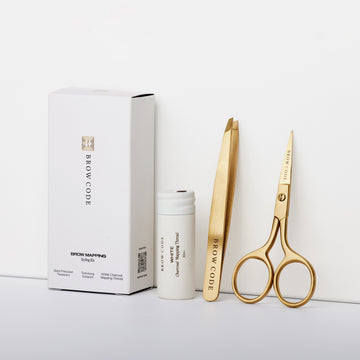Das Brow Code AT HOME KIT Brow Mapping & Styling besteht aus goldenen Werkzeugen in einem weißen Etui, ideal für die präzise Formung der Augenbrauen. Blashy Shop