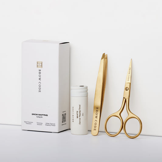 Das Brow Code AT HOME KIT Brow Mapping & Styling besteht aus goldenen Werkzeugen in einem weißen Etui, ideal für die präzise Formung der Augenbrauen. Blashy Shop
