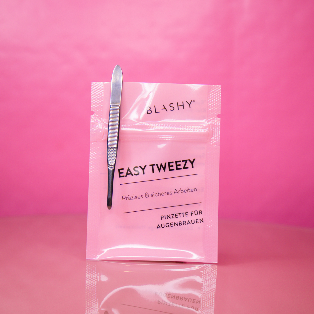 Eine BLASHY EASY TWEEZY Augenbrauen-Pinzette - rund von Blashy ist auf einem rosa Päckchen auf einem leuchtend rosa Hintergrund aufgeklebt. Blashy Shop