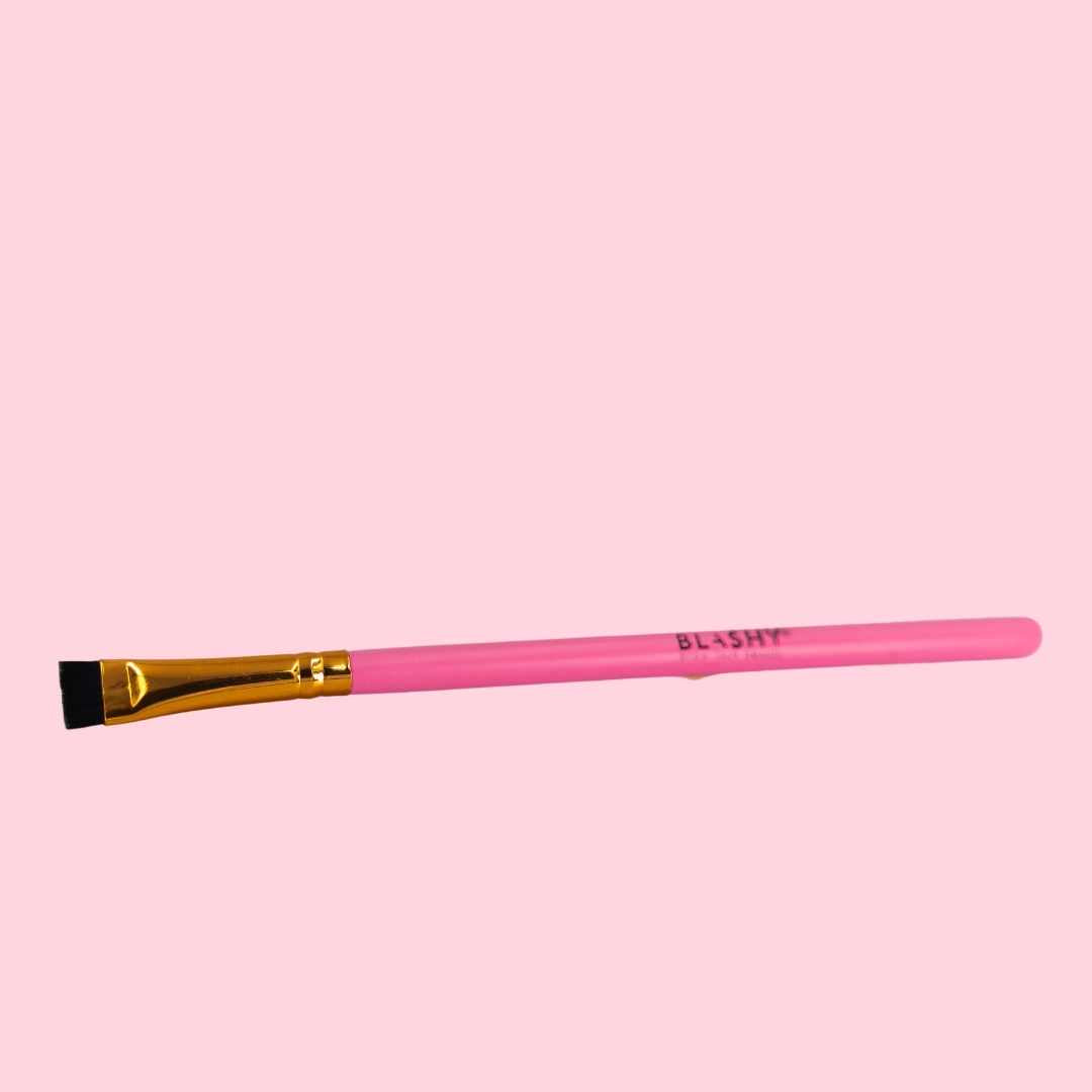 Der Blashy Styling Pinsel für Augenbrauen in Rosa - ideal für Augenbrauen - hat einen rosa Griff und eine goldene Zwinge. Blashy Shop
