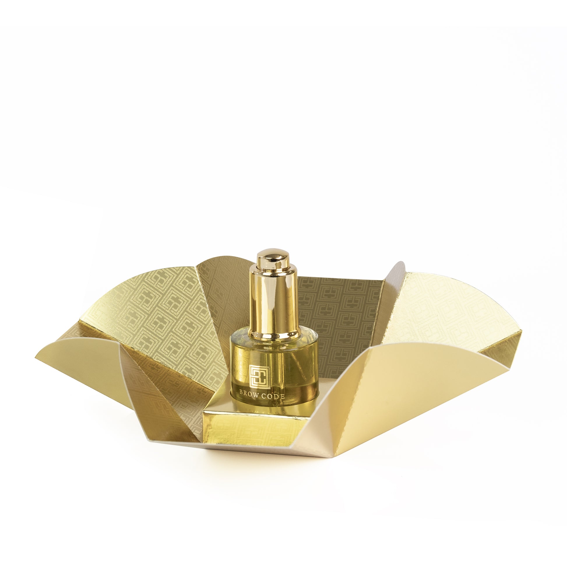 Ein goldenes Fläschchen Brow Code Brow Gold Oil pflegendes Wachstumsöl, 30ml, abgebildet in offener Goldverpackung auf Weiß. Blashy Shop