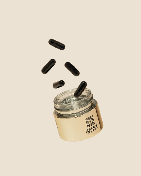 Ein offener Glastiegel mit darüber schwebender Brow Code Brow Henna Pulverkapsel - Refill oder Tester auf beigem Hintergrund. Blashy Shop