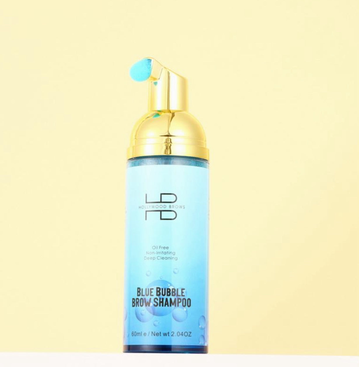 Hollywood Brows Bubble Brow Shampoo Schaum in rosa & blau, goldene Pumpe, auf gelbem Hintergrund. Blashy Shop