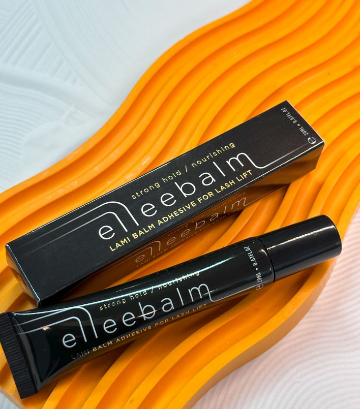 Elleebana Elleebalm Lami Balm Glue 20ml (vegan) Tube und Schachtel auf einer strukturierten orangen und weißen Oberfläche. Blashy Shop