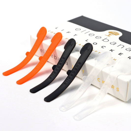 Fünf Elleebana Lash Lift Locker Silikonpads in drei Farben liegen auf einer orange-schwarzen Elleebana-Box. Blashy Shop