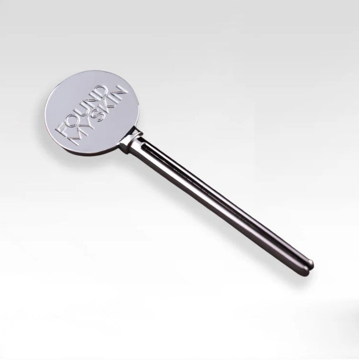Das FOUND MY SKIN Tuben Squeezer Tool und der gravierte Metallspatel werden zusammen auf einem schlichten Hintergrund gezeigt. Blashy Shop