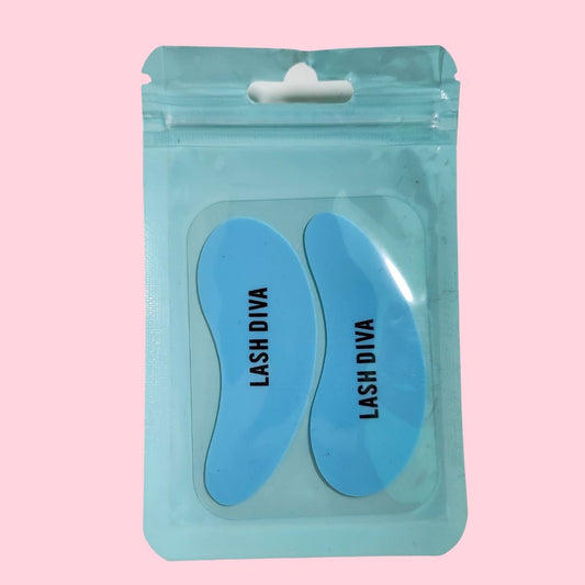 Ein versiegelter blauer Beutel mit Blashy C Silikon Augenpads mit ausgefallenem Aufdruck, 1 Paar, dargestellt auf einem rosa Hintergrund. Blashy Shop
