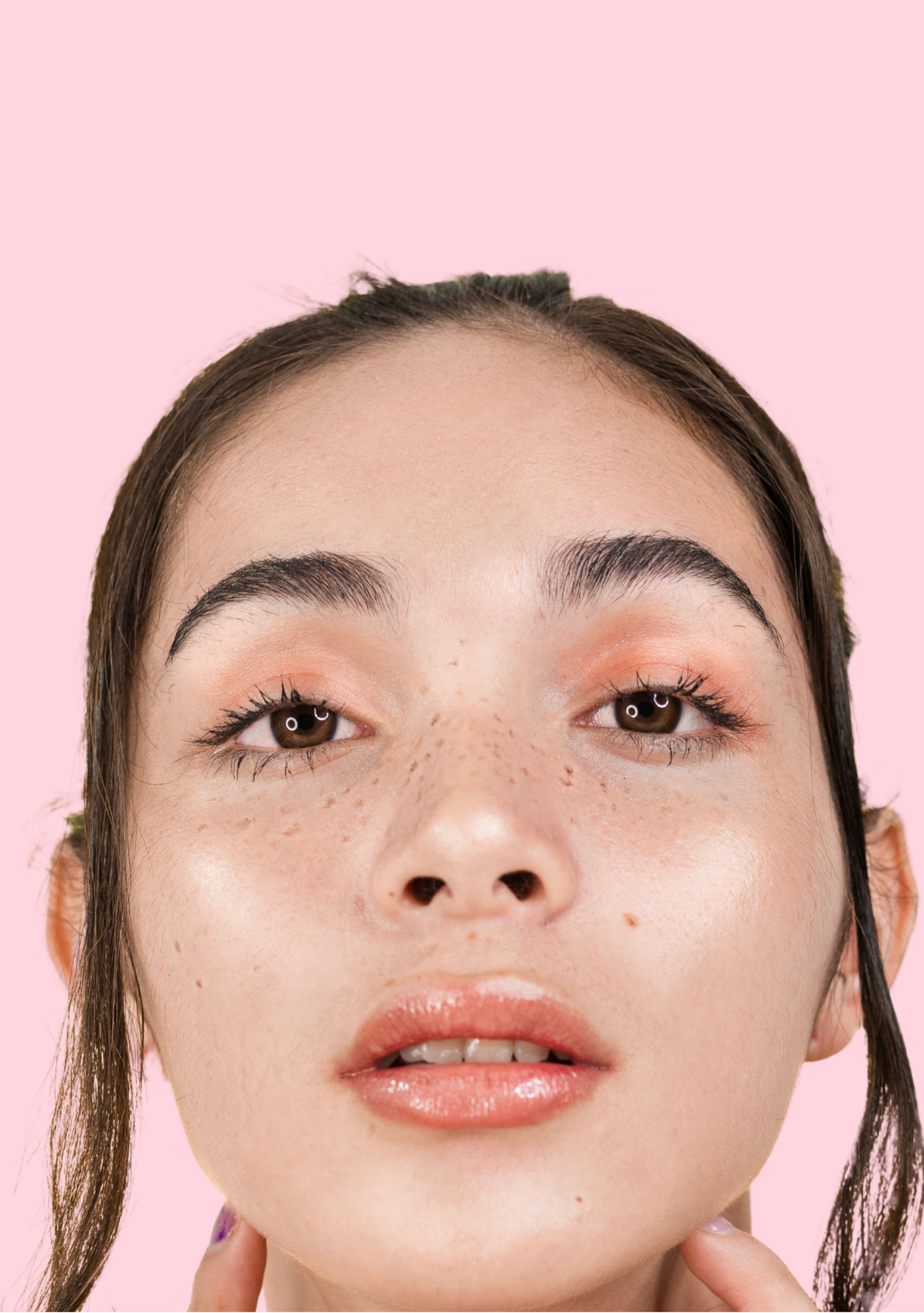 Junge Frau mit taufrischer Haut, glänzenden Lippen und pfirsichfarbenem Augen-Make-up, trägt SOMMERSPROSSEN von Lash & Brow Academy. Blashy Shop