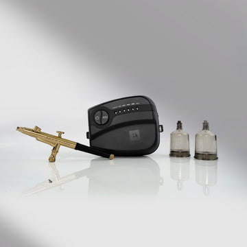 A Brow Code STARTER KIT Airbrush mit 10 Hybridfarben, Airbrush-Maschine und Zubehör auf einer reflektierenden Oberfläche. Blashy Shop