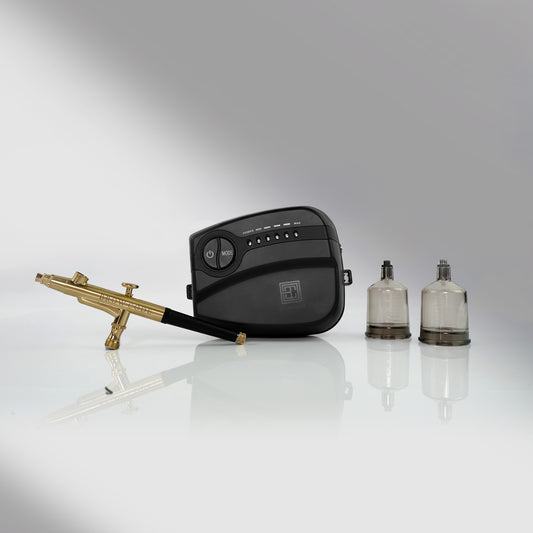 A Brow Code STARTER KIT Airbrush mit 10 Hybridfarben, Airbrush-Maschine und Zubehör auf einer reflektierenden Oberfläche. Blashy Shop